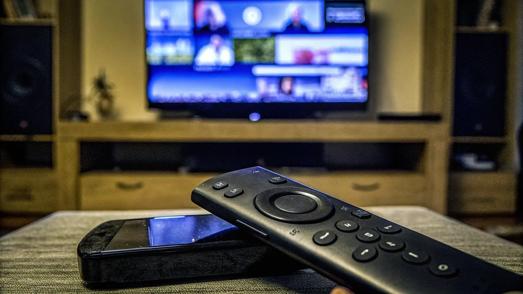 Fire TV remote in front of a TV showing a streaming app